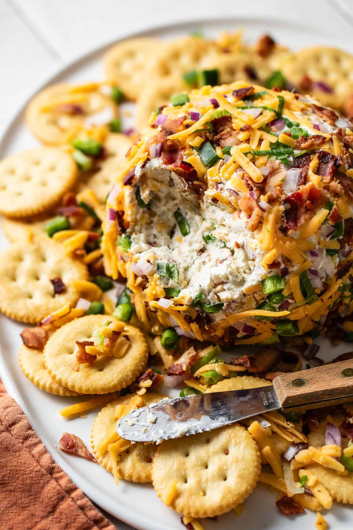 A ball of cheese on a serving plate with Ritz crackers on the side.