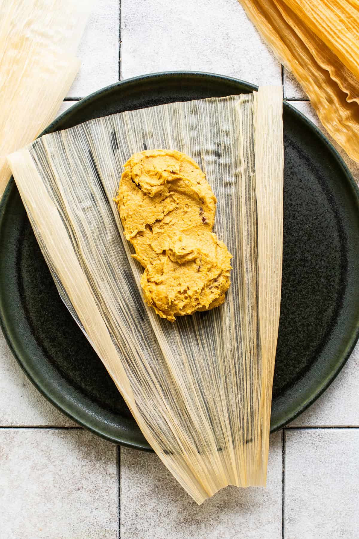 Pumpkin tamales in the making - the raw masa dough on a corn husk before being folded and assembled.