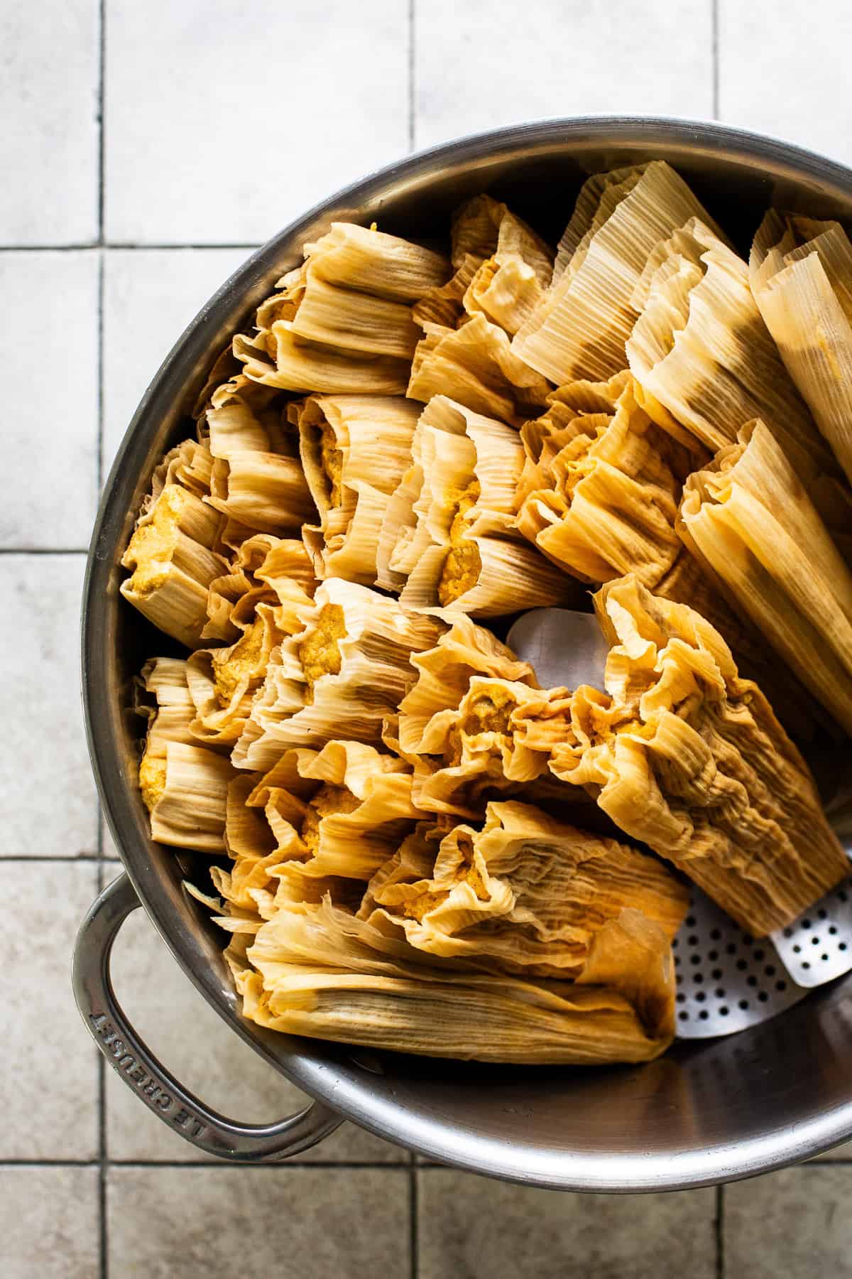 Pumpkin tamales in a steamer pot ready to be steamed and cooked.