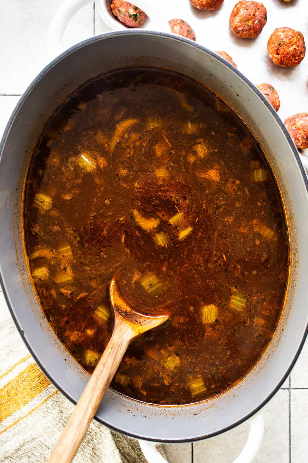 Albondiga soup cooking on the stove in a large Dutch oven.