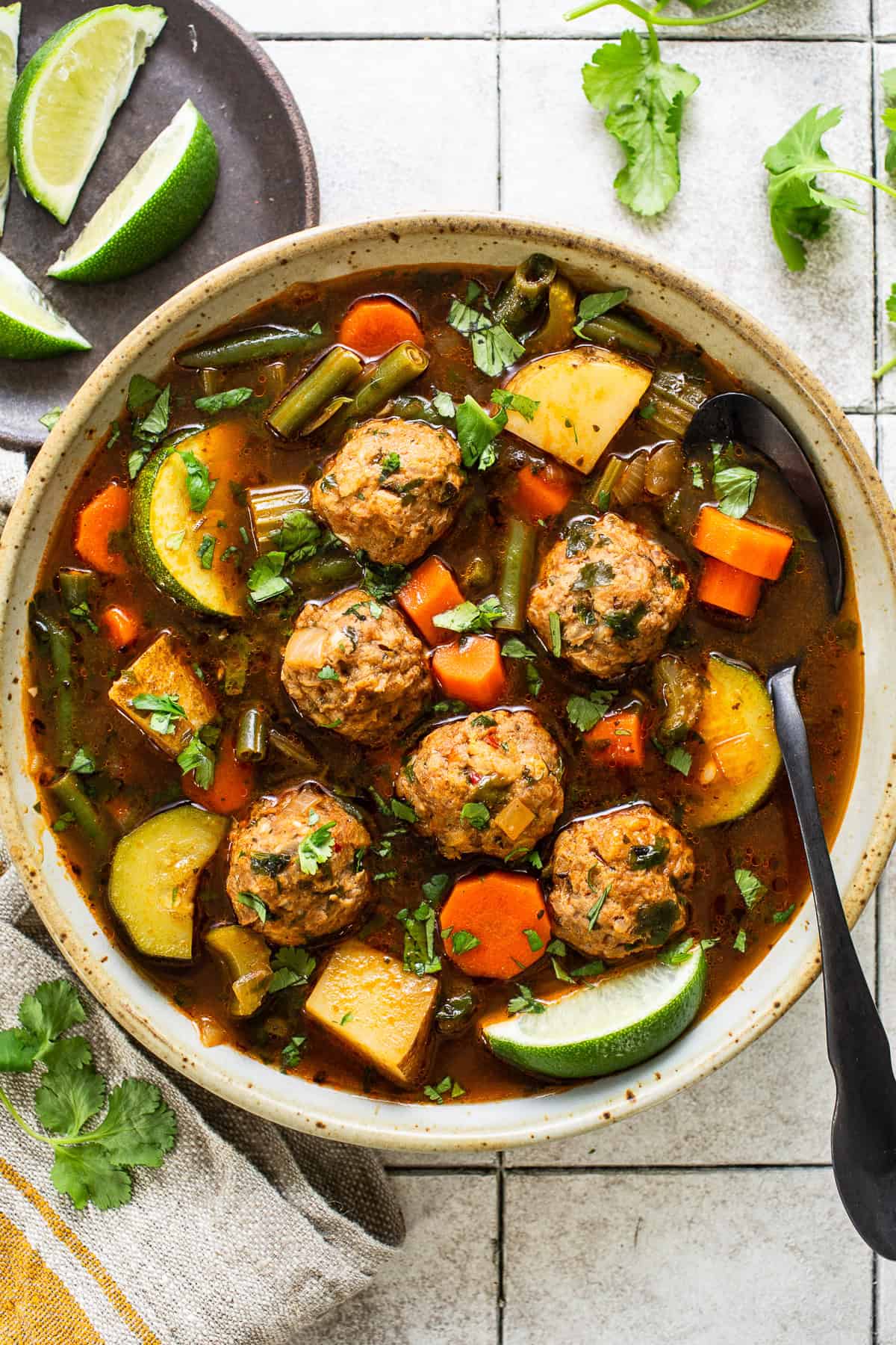 Albondigas soup in a bowl with delicious mexican meatballs, carrots, zucchini, green beans, and potatoes in a flavorful tomato-based broth.