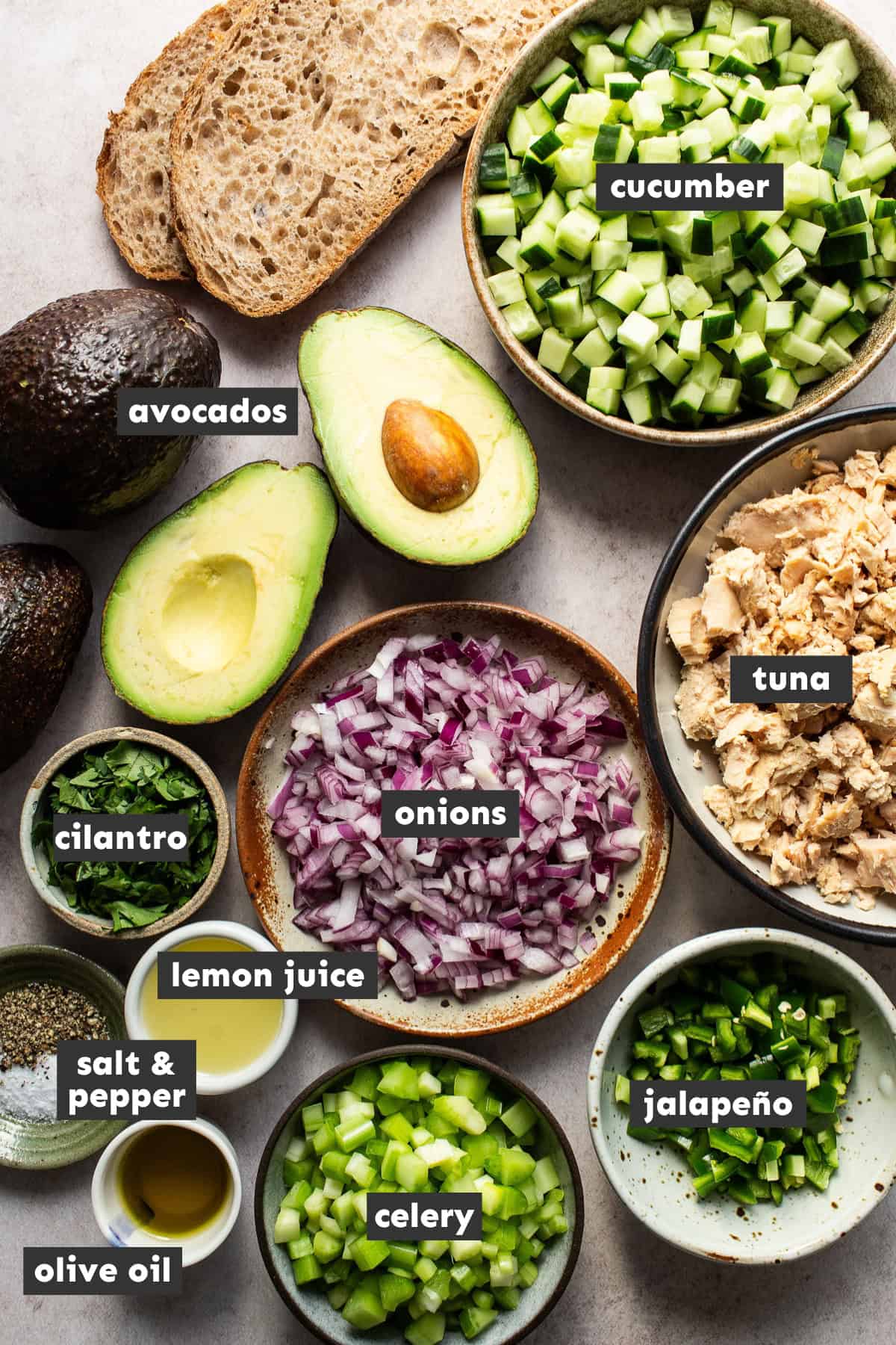 All of the ingredients you need for an avocado tuna salad measured out and placed on a table ready to use.  