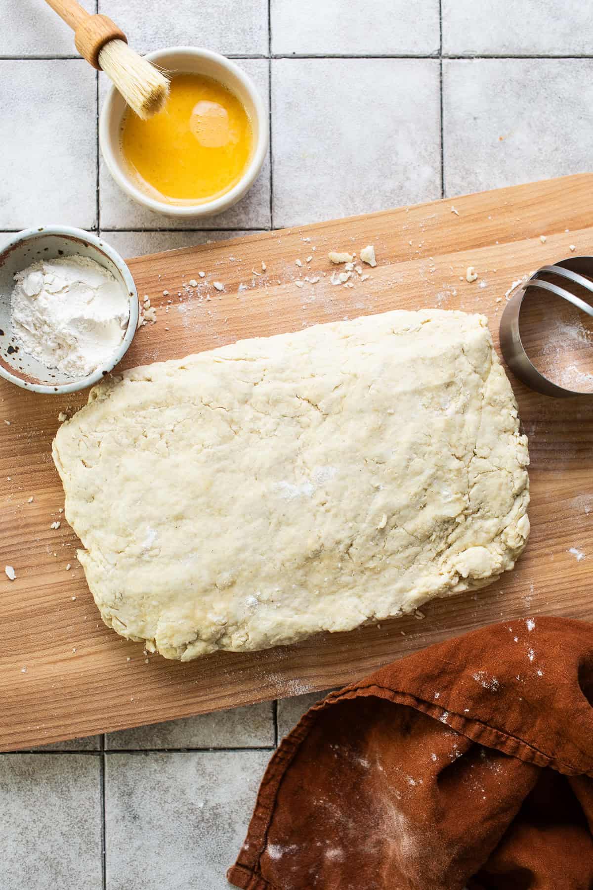 The dough for masa harina biscuits on a cutting board shaped into a rectangle.