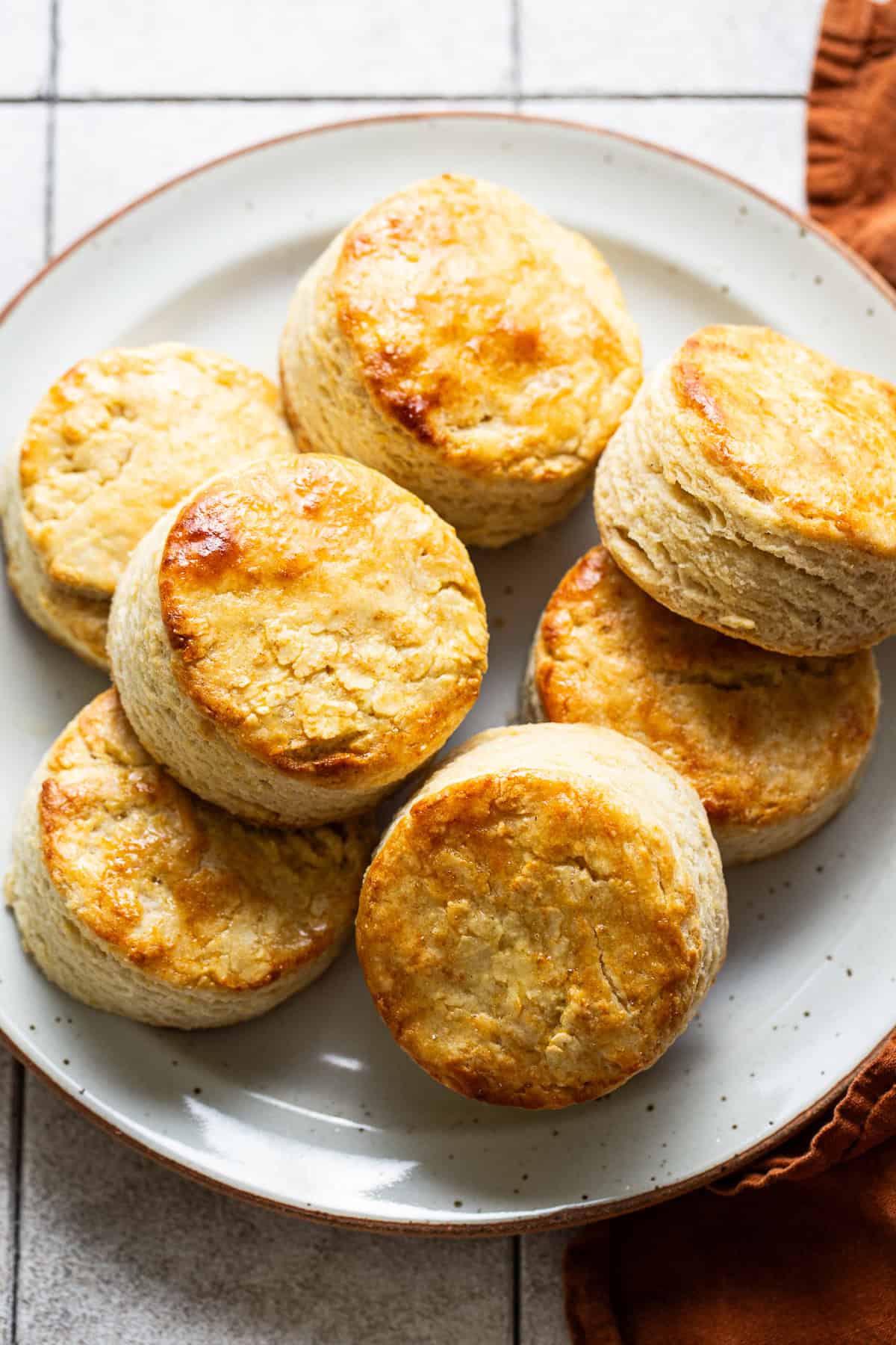 A plate of masa harina biscuits with light golden brown tops and layers of flaky dough ready to eat.