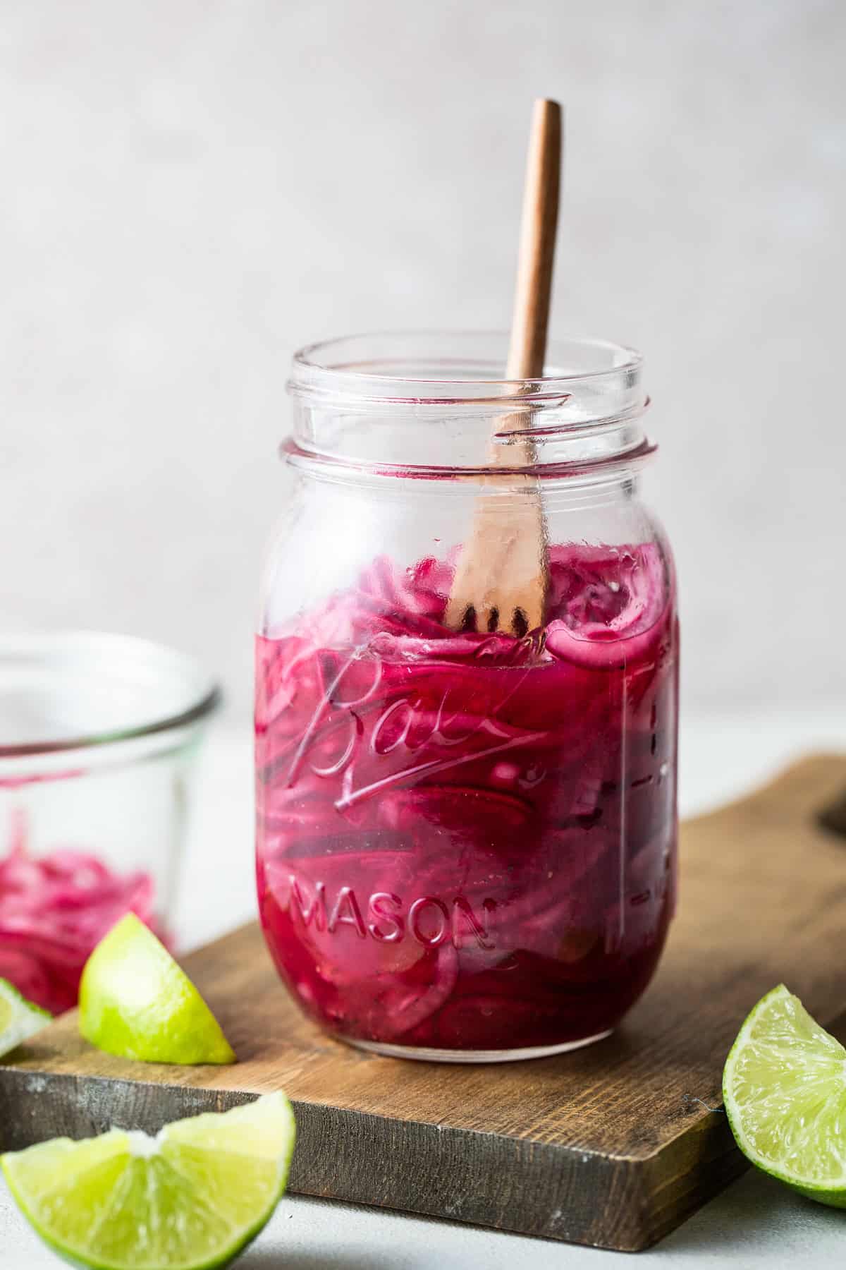 A jar of bright pink Mexican pickled red onions ready to be served.