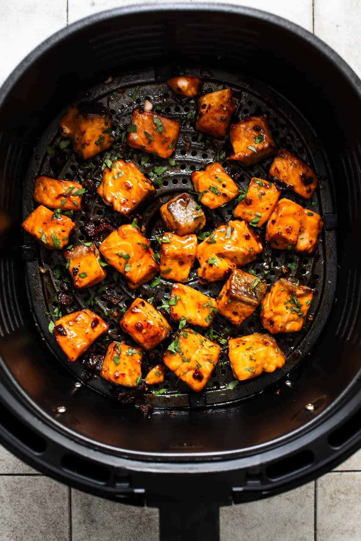 Crispy air fryer salmon bites garnished with chopped cilantro.