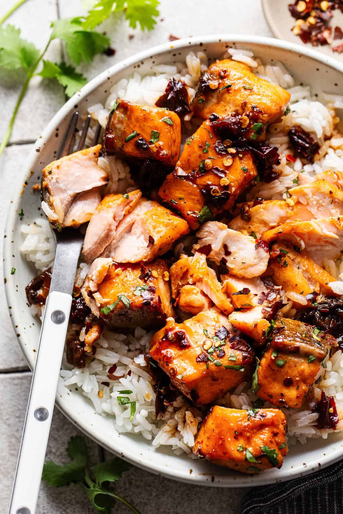 Flaky air fryer salmon bites on a plate with white rice.