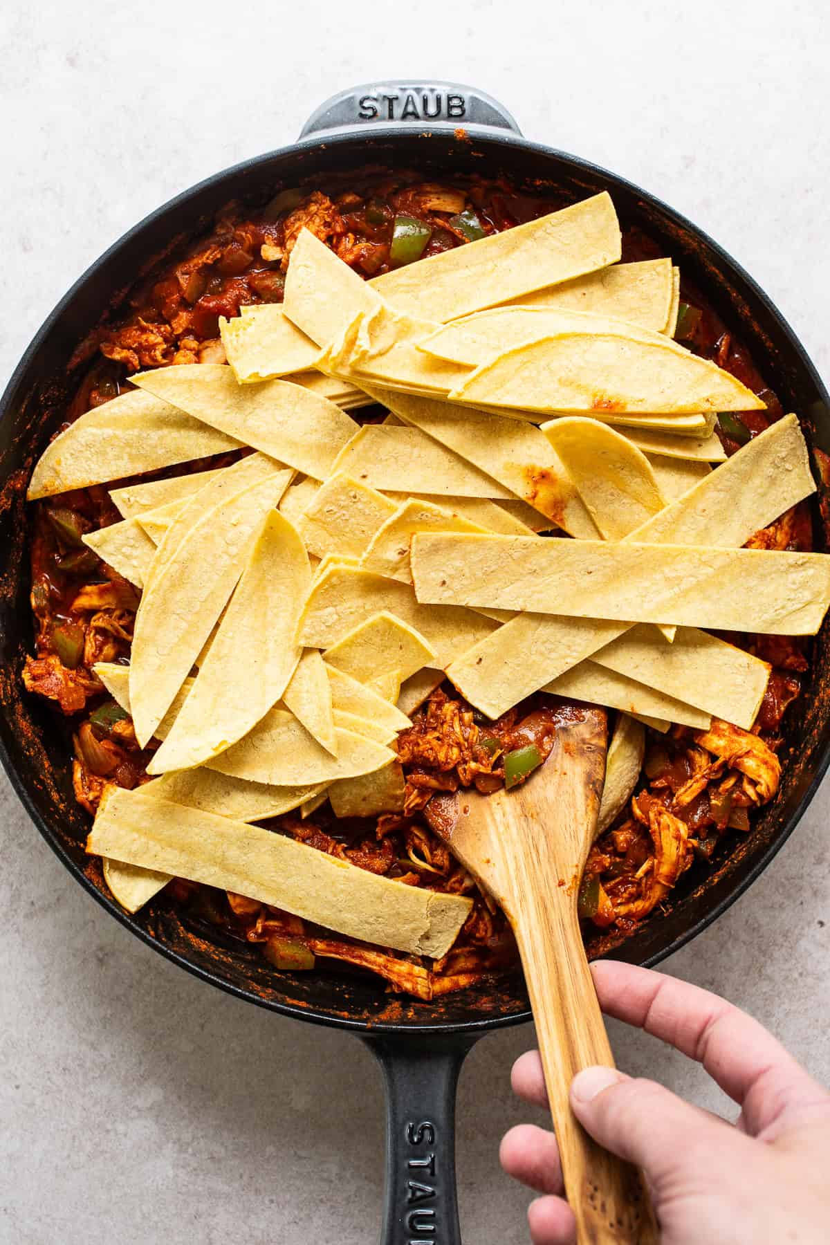 Stir in corn tortillas that have been cut into stips.