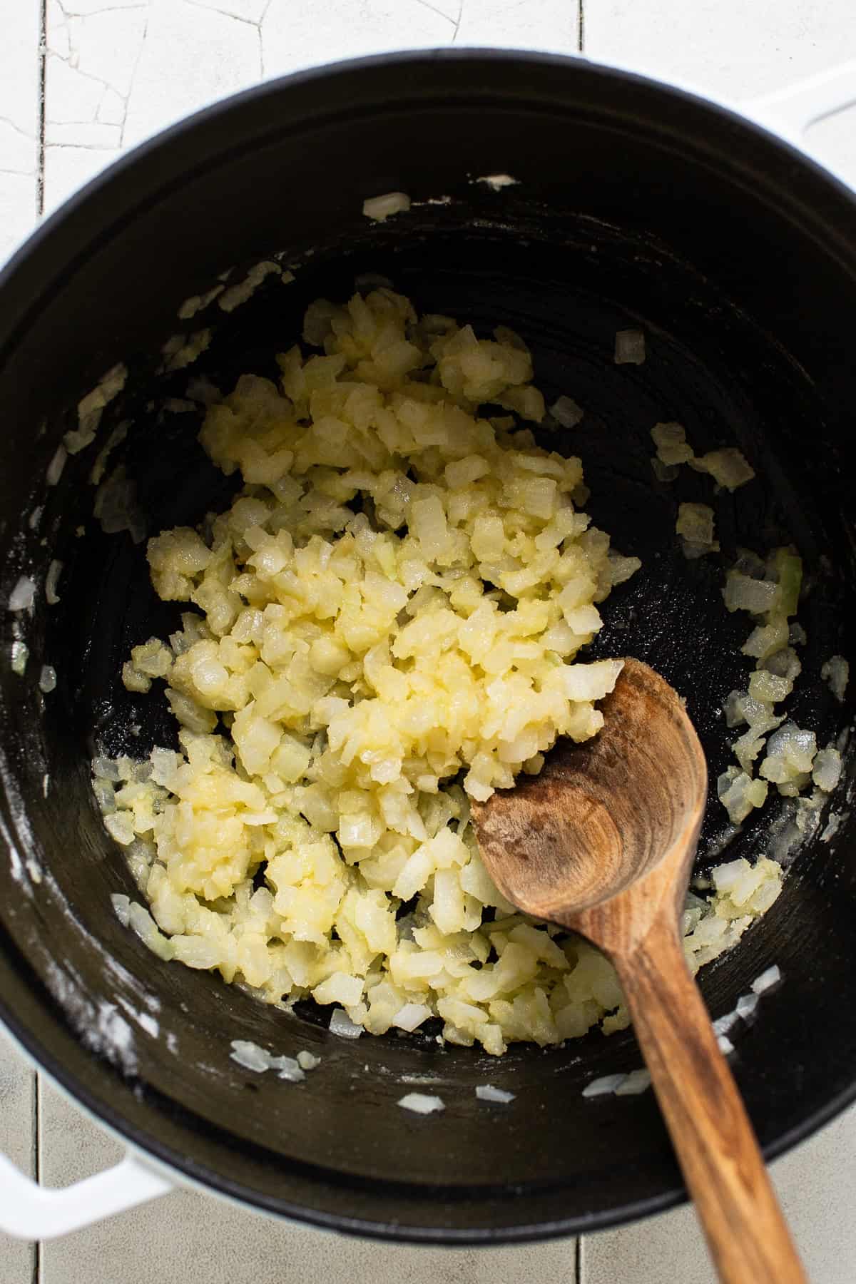 Sautéing vegetables in a small pot with seasonings.