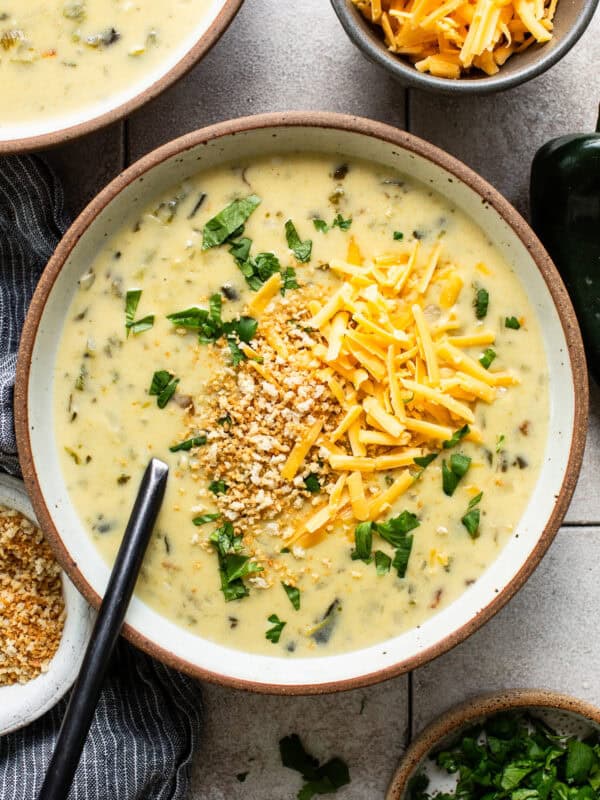 Chile relleno soup served in a bowl with cheese on top.