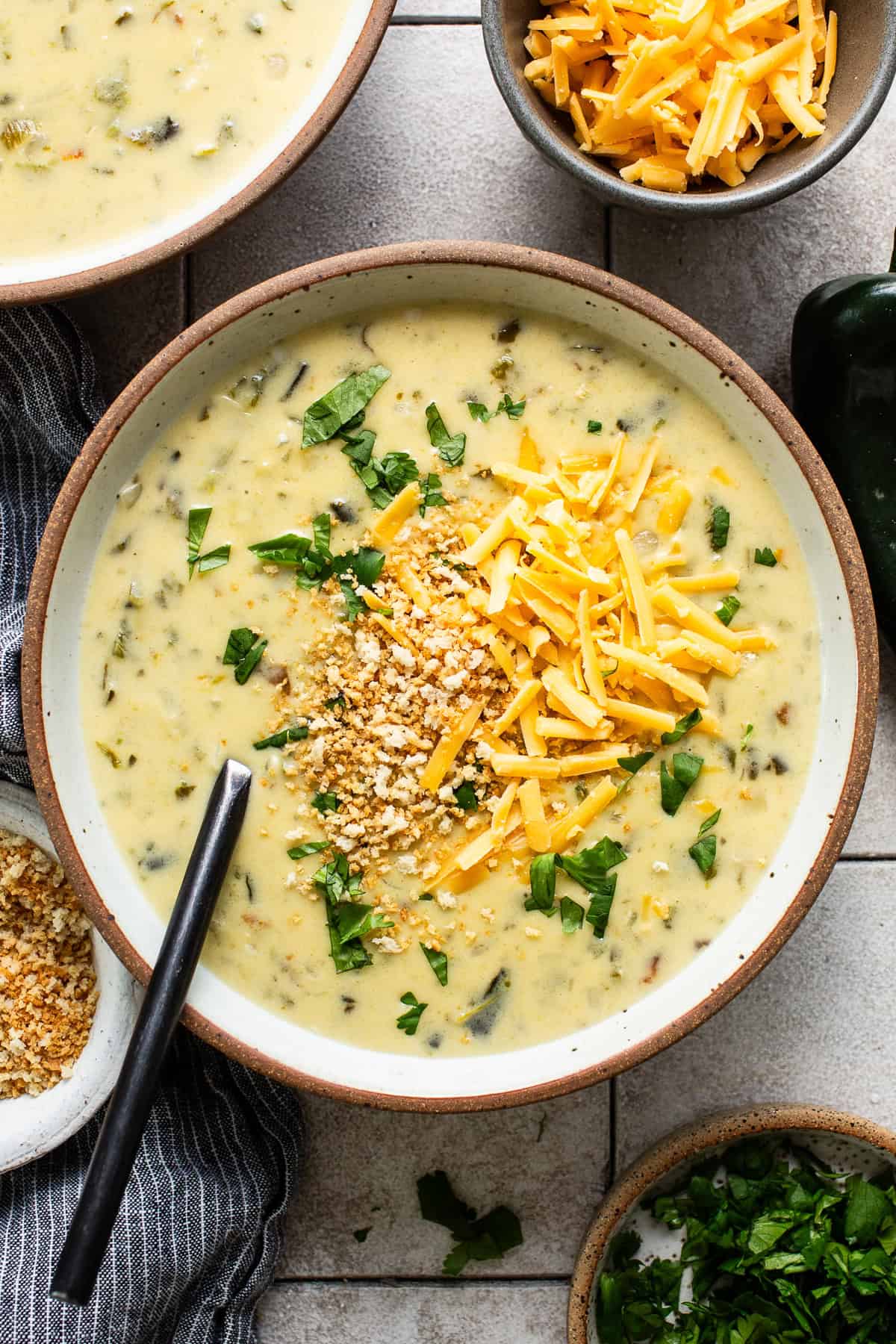 Chile relleno soup served in a bowl with cheese on top.