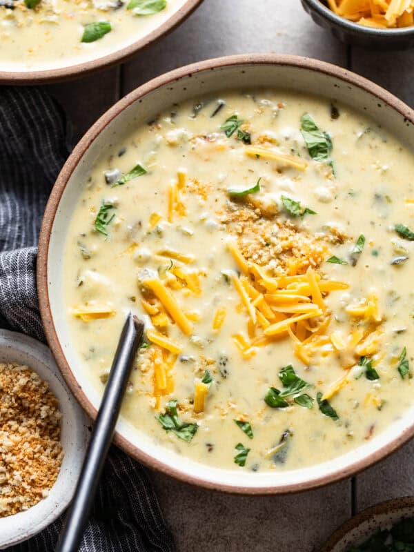 Creamy chile relleno soup in a bowl topped with cilantro and shredded cheese.