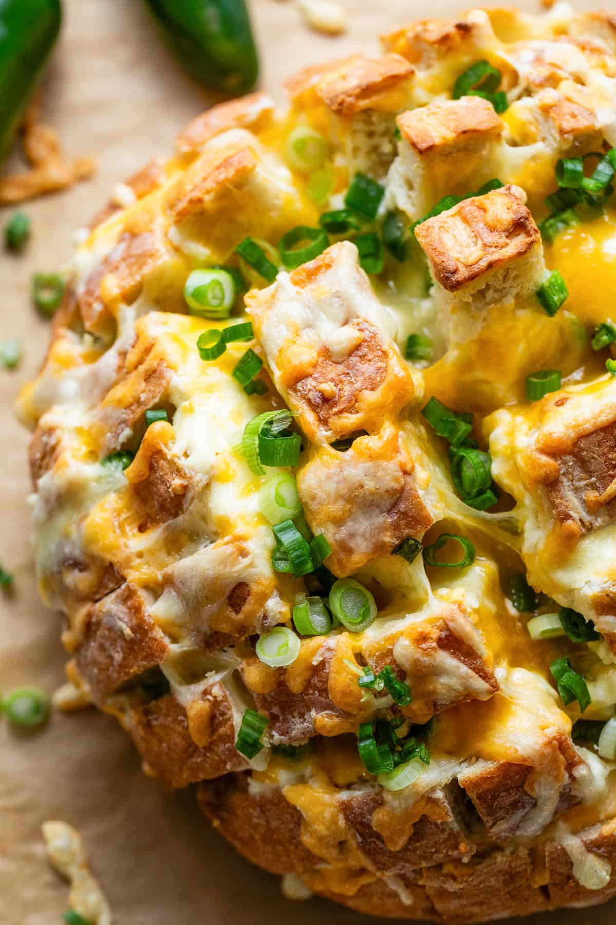 Baked jalapeno pull apart bread with green onions as garnish.