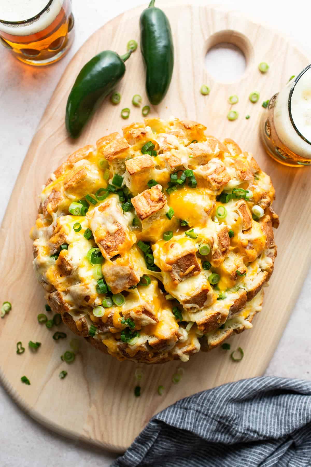 Jalapeno popper pull apart bread baked and set on a cutting board ready to serve.