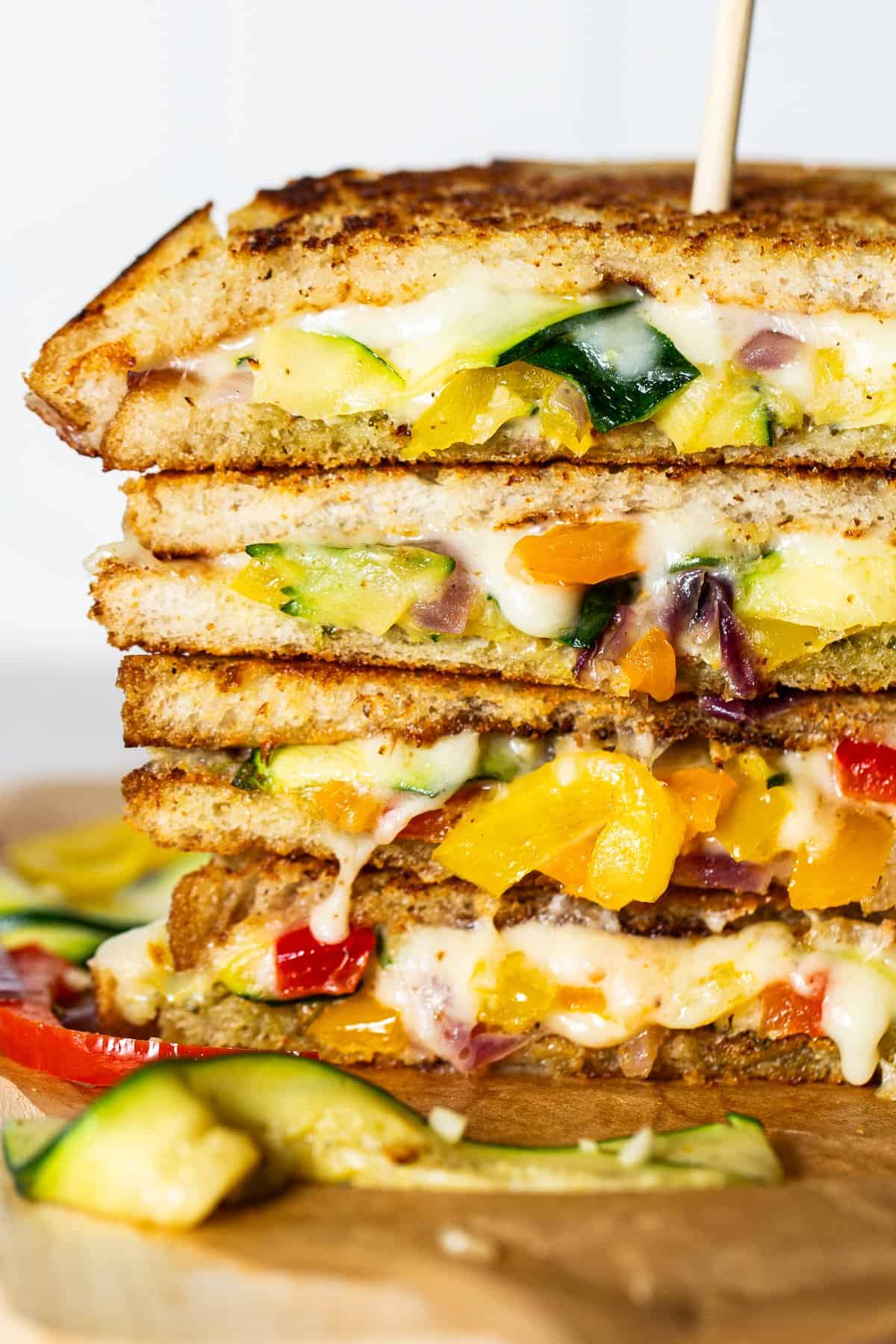 Fajita grilled cheese served on a plate, cut in half, and stacked on top of one another with a skewer in between.