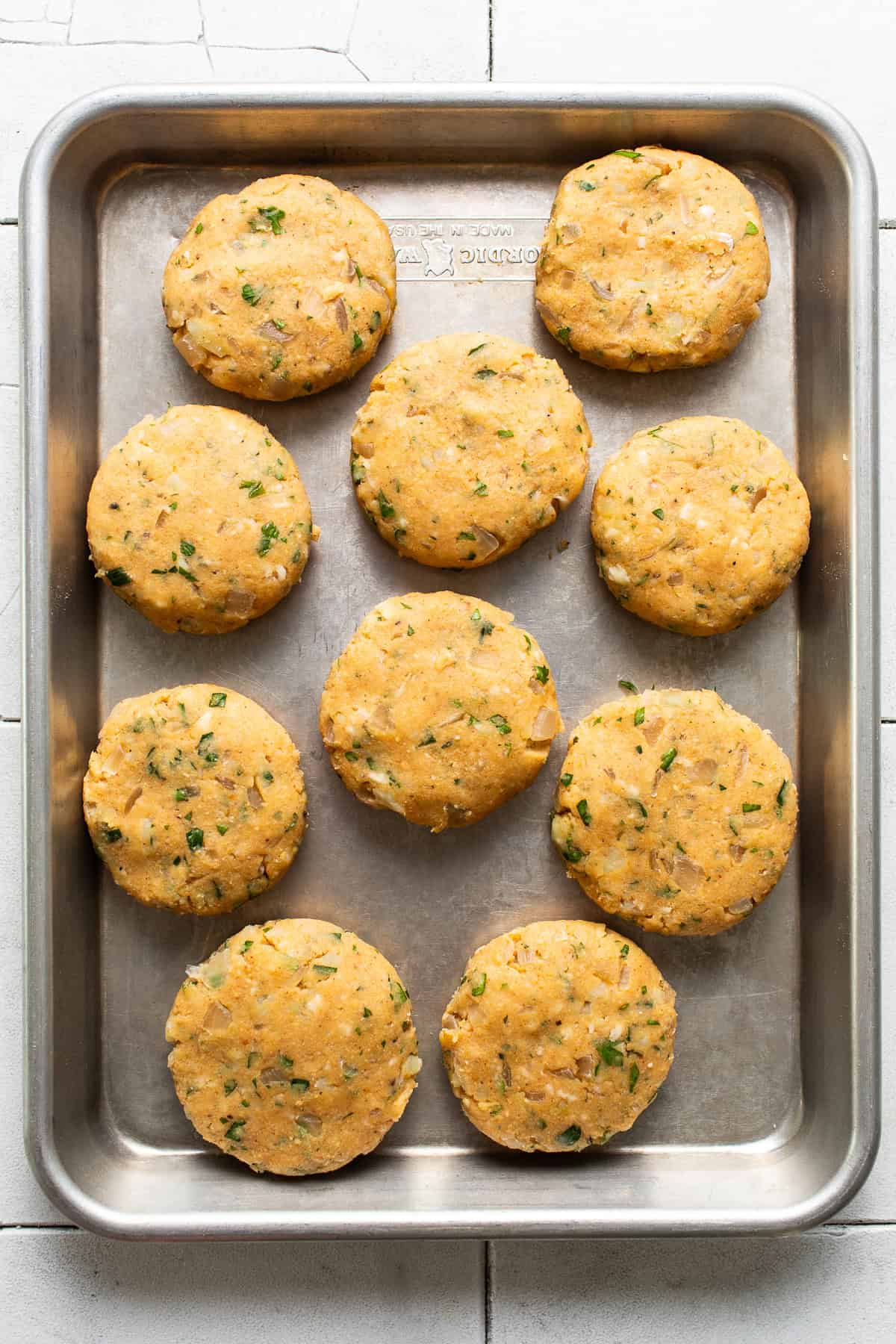 Baking sheet lined with the potato mixture shaped patties.