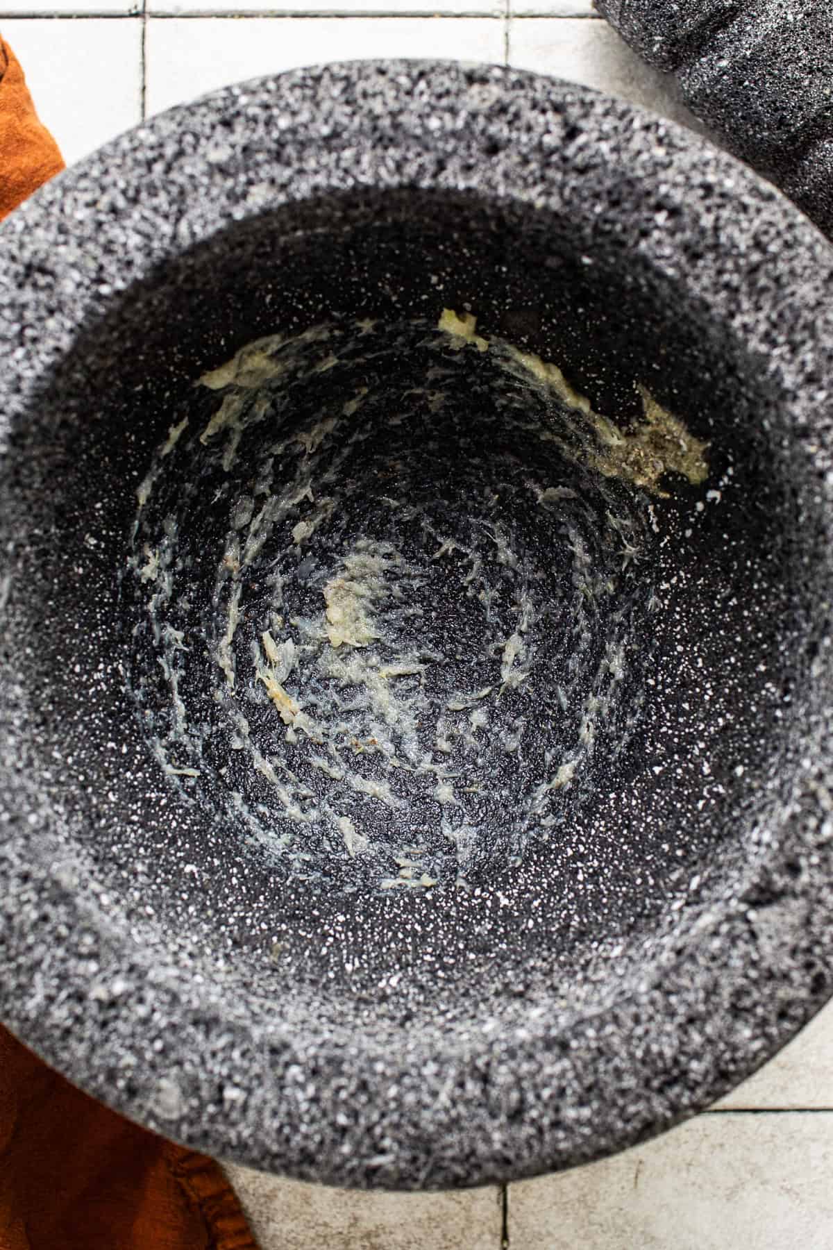 A molcajete with salt and garlic ground into it.